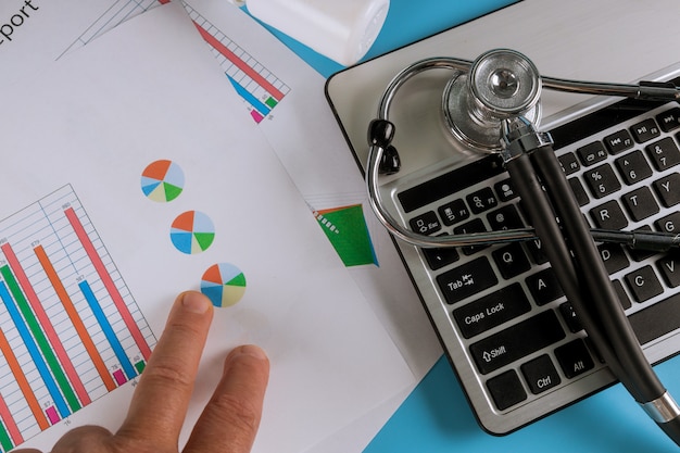 Stethoscope in doctors desk with keyboard pills. Top view