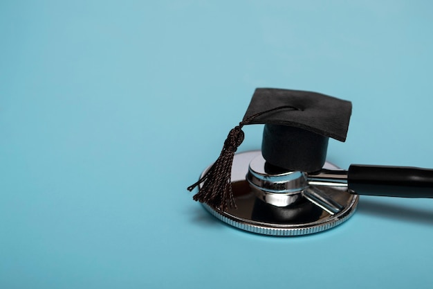 Stethoscope and graduate hat, on a blue background, top view, medical background graduate achievement, background