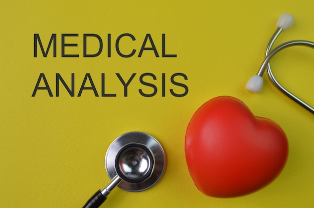 Stethoscope and heart shape on yellow background with text MEDICAL ANALYSIS