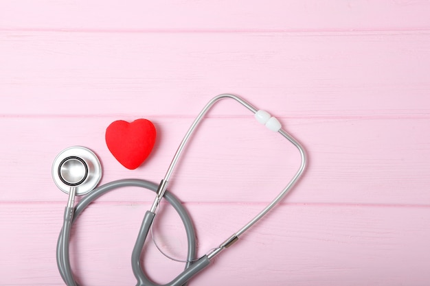 Stetoscopio e cuore su fondo in legno salute medicina