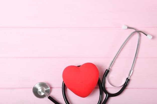 Stetoscopio e cuore su fondo in legno salute medicina