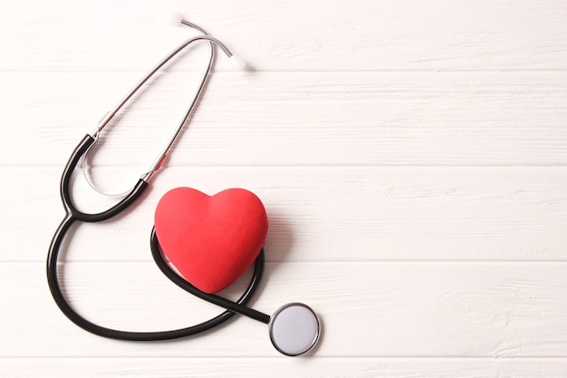 Stethoscope and heart on wooden color background health medicine