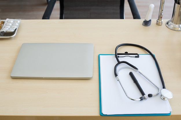 Photo stethoscope and laptop and other medical object on table of doctor.