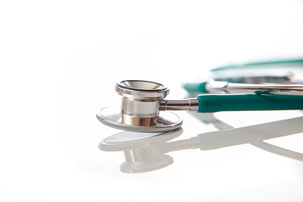 Stethoscope lies on a white table with reflection