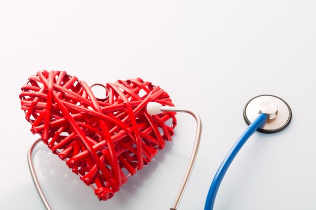 Photo stethoscope listening to decorative red heart on white table