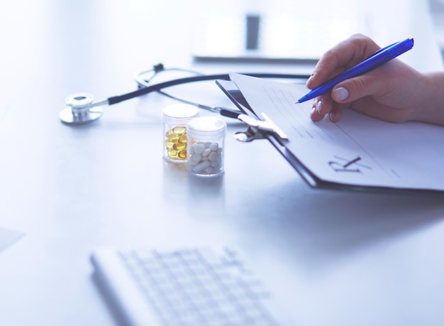 Stethoscope lying on glass desk with laptop computer at busy physician background Medicine or pharmacy concept Medical tools at doctor working table