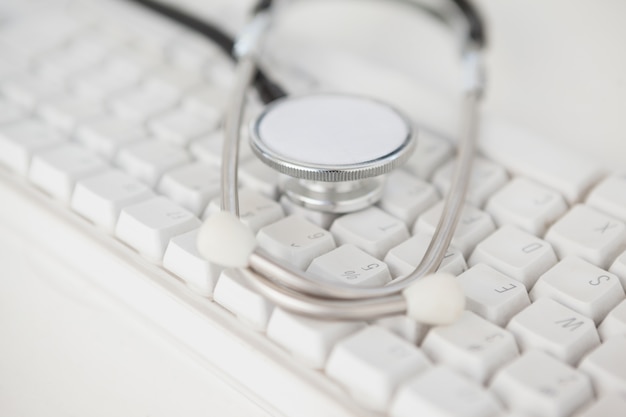 Stethoscope lying on white keyboard