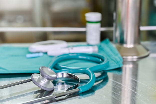 Stethoscope and medical equipment tool on treatment table in hospital .