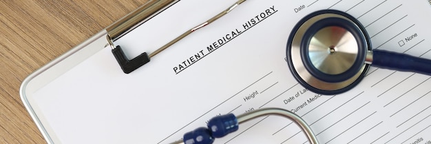 Stethoscope and medical pills on blank patient medical history form pinned to clipboard concept