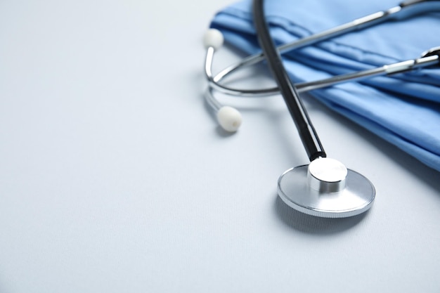 Stethoscope and medical uniform on light background Space for text