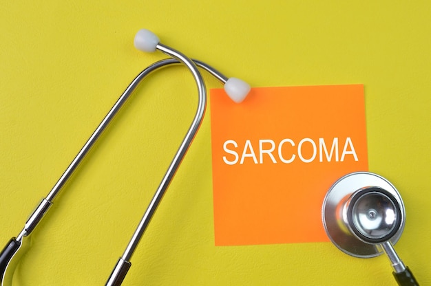 청진기 및 텍스트가 있는 주황색 메모 SAARCOMA Sarcoma는 악성 종양이자 암의 일종입니다.