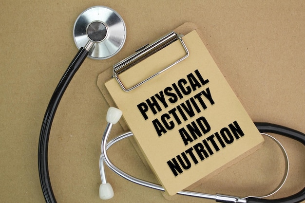 Photo stethoscope and paper board writing with the words physical activity and nutrition