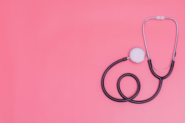 Stethoscope on pink background and copy space