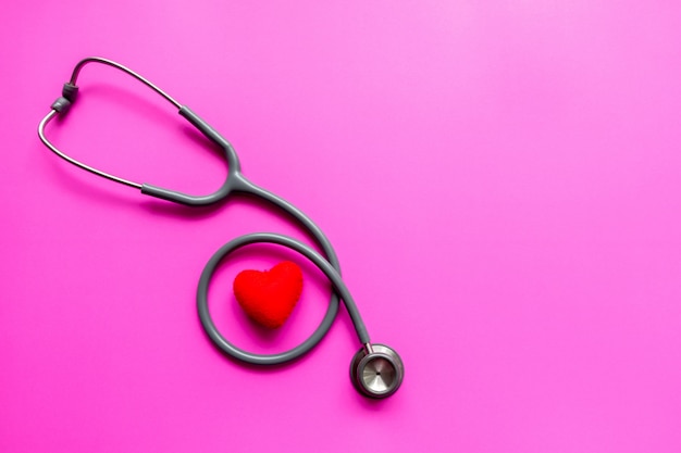 Stethoscope on a pink background with space for text.