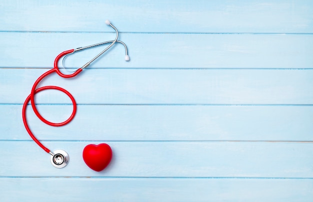 Photo stethoscope and red heart on blue wooden