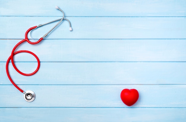 Stethoscope and red heart on blue wooden