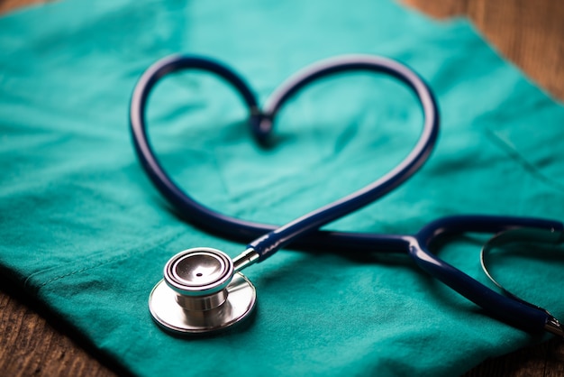 A stethoscope shaping a heart on a medical uniform, closeup