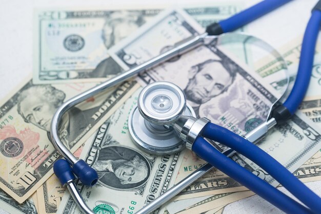 A stethoscope sits on a tangle of dollars