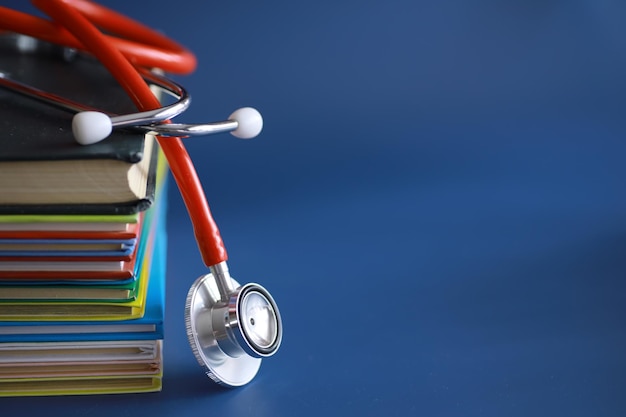 Stethoscope on stack of medical guide book for doctor learning treatment at hospital
