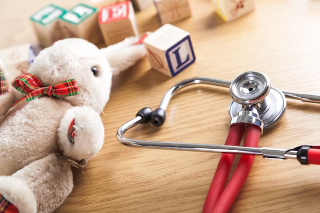 Stethoscope toys and box text on wooden table background.