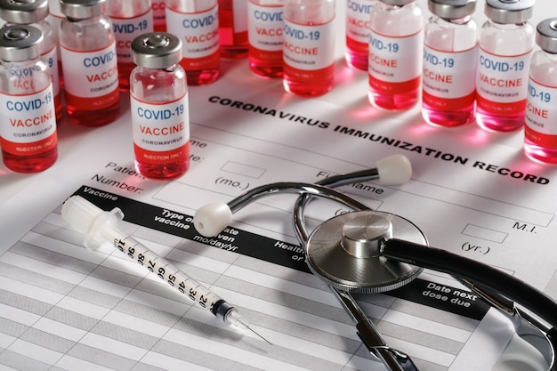 Stethoscope and vaccine vial glass bottles on background for vaccination