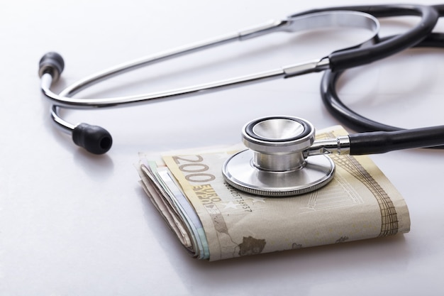 a stethoscope on a wad of euro bills,