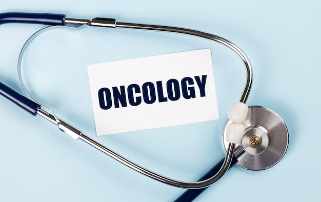 파란색 배경 의료 개념에 ONCOLOGY 텍스트가 있는 청진기 및 흰색 카드