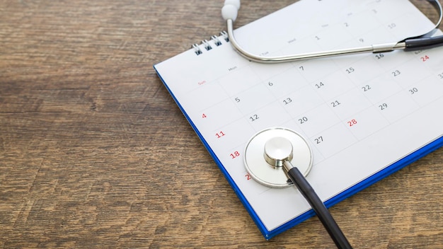 Photo stethoscope with date on a calendar page on a wooden floor healthcare concept