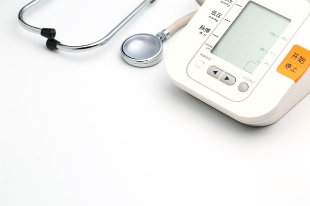 Stethoscope with Electronic Blood Pressure Monitor or Sphygmomanometer on the white background. Healthcare concept.