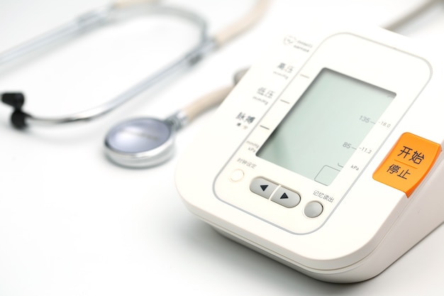 흰색 바탕에 전자 혈압계 또는 혈압계가 있는 청진기. 의료 개념입니다.