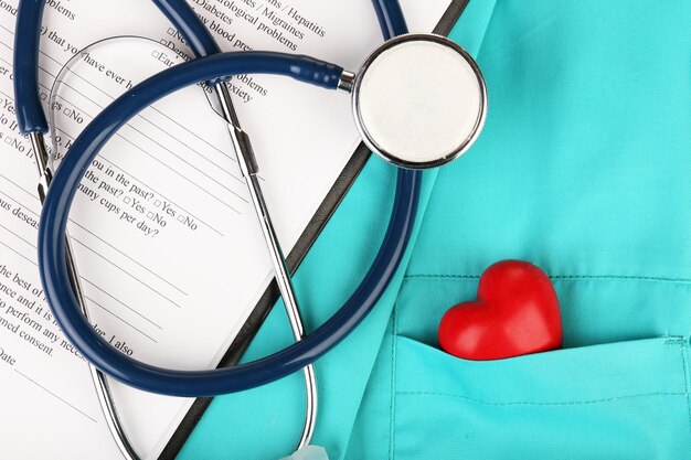 Stethoscope with heart on suit background closeup