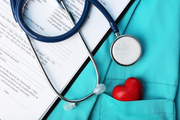 Stethoscope with heart on suit background closeup