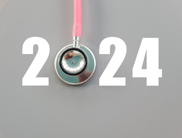 Foto stetoscopio con il numero 2024 su sfondo grigio buon anno per l'assistenza sanitaria e copertina del calendario