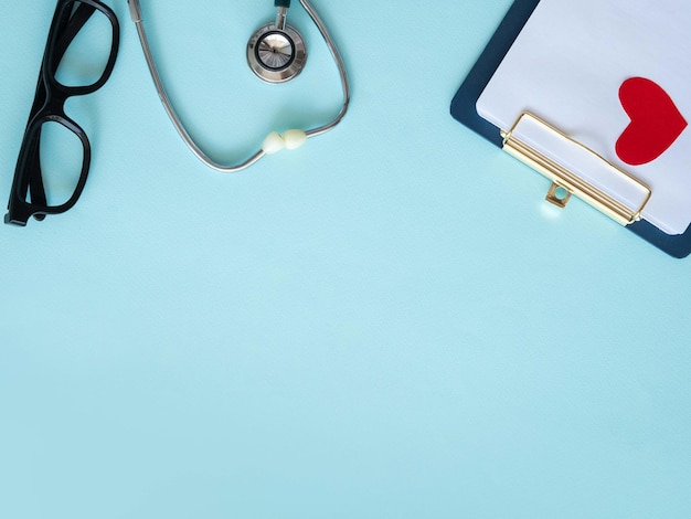 Photo stethoscope with a red heart on a blue background with a place for text concept