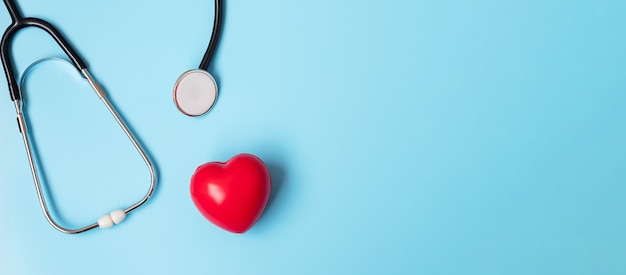 Stethoscope with Red heart shape on blue background 