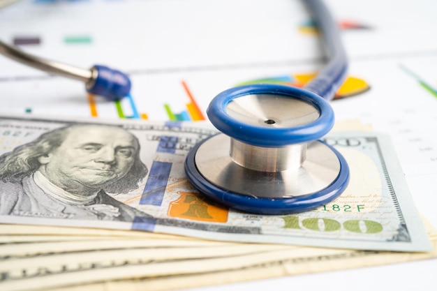 Stethoscope with US dollar banknotes on graph Finance Account Statistics Investment economy and Business company concept