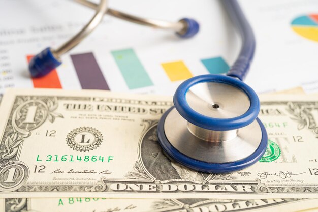 Photo stethoscope with us dollar banknotes on graph finance account statistics investment economy and business company concept