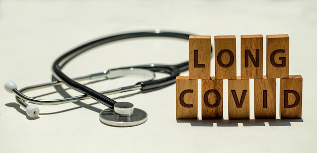 Stethoscope and wooden blocks with wording LONG COVID