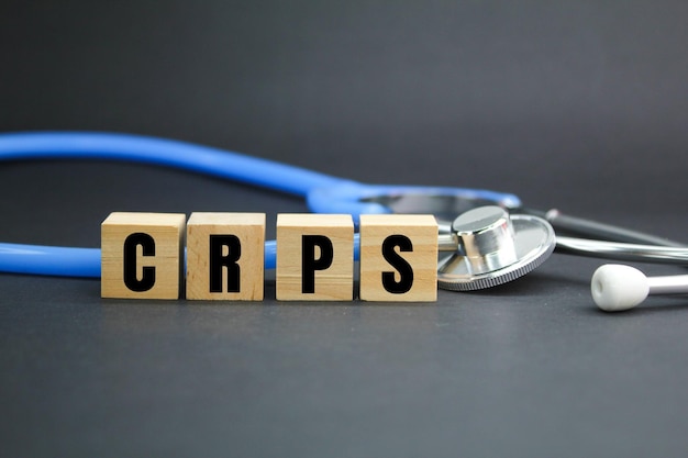 stethoscope and wooden cube with the letters CRPS or the word complex regional pain syndrome