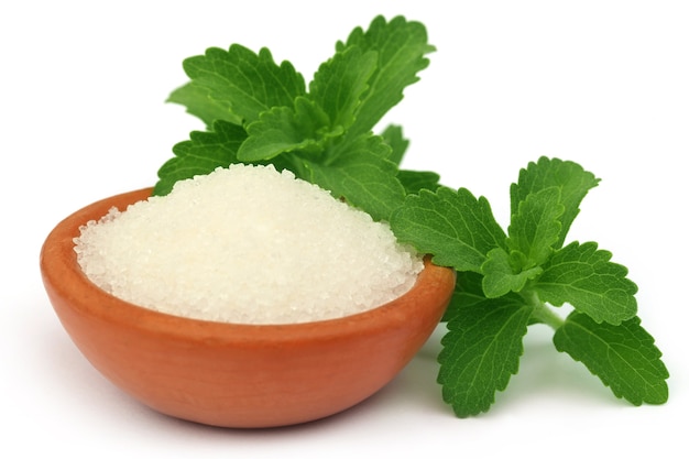 Stevia with sugar on a brown bowl over white background