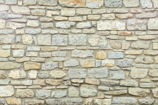 Stevige gele en beige stenen muur Stenen achtergrond