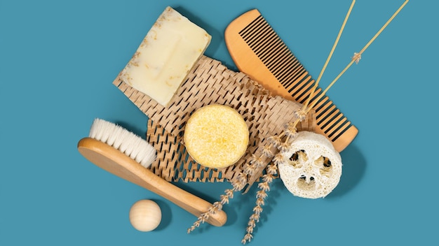 Stevige vaste shampoo naturel Luffa spons houten kam en borstel op honingraatpapier diepblauwe achtergrond Plasticvrij zero waste living low water ingrediënten Duurzame haarverzorging