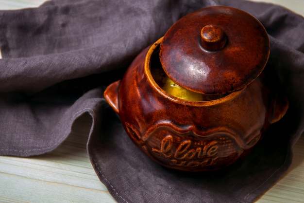 Stew in a clay pot on a wooden board.