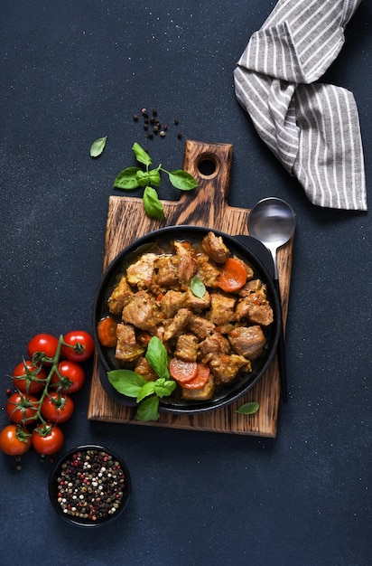 Stufato con spezie pomodori e carote su uno sfondo di cemento cheno