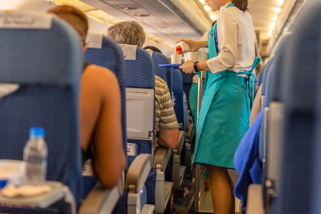 Stewardess serveert drankjes aan passagiers aan boord.