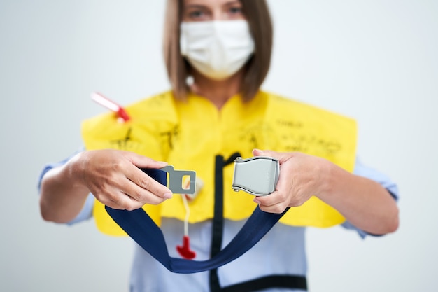 Photo stewardess wearing protective mask and explaining aircraft rules isolated over white background