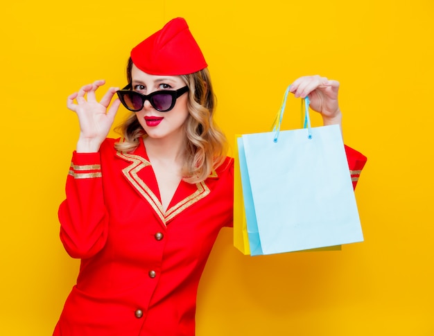 stewardess wearing in red uniform with shopping bags.