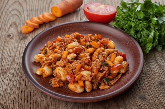 Stewed beans with vegetables and herbs in a plate