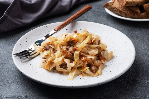 Stewed cabbage with meat on a plate.