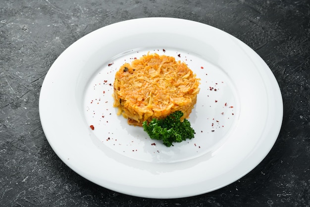 Stewed cabbage with onions on a plate Top view